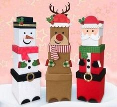 three paper bags with santa claus, snowman and reindeer on them are standing in the snow