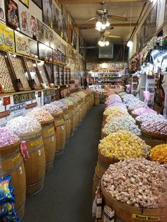 a store filled with lots of different types of flowers and plants in wooden buckets