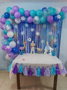 the table is set up with balloons and streamers for an ice princess birthday party