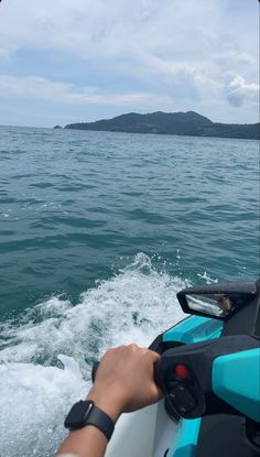 a person riding on the back of a blue and white boat