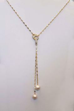 Our Pearl Lariat Necklace is a stunning piece of jewelry designed to make a bold statement. This necklace features 2 freshwater pearls handwrapped onto a gold sequin chain. crafted from high-quality materials, creating a luxurious and contemporary look. The lariat style adds a touch of elegance and versatility, allowing you to adjust the length and drape to suit your outfit and preference. The focal point of this necklace is our stunning carabiner pave clasp that adds a stunning contemporary fla Elegant Pearl Charm Dangle Lariat Necklace, Luxury Pearl Lariat Necklace, Elegant Pearl Charm Lariat Necklace With Dangle, Elegant Lariat Necklace With Pearl Charm Dangle, Elegant Adjustable Chain Pearl Necklace, Elegant Adjustable Pearl Necklace With Chain, Elegant Pearl Lariat Dangle Necklace, Elegant Pearl Dangle Lariat Necklace, Elegant Pearl Lariat Necklace With Dangle