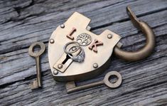 an old lock and some keys on a wooden table