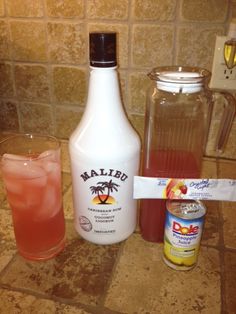 some drinks are sitting on the counter next to a bottle and a glass with something in it