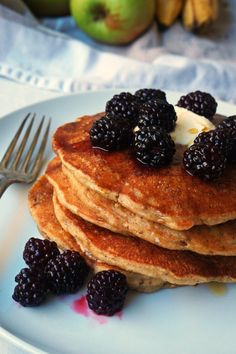 a stack of pancakes topped with berries and butter