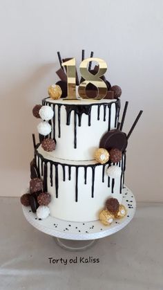 a three tiered cake with white frosting and chocolate decorations