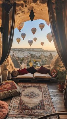 a living room filled with lots of furniture and balloons flying in the sky above it