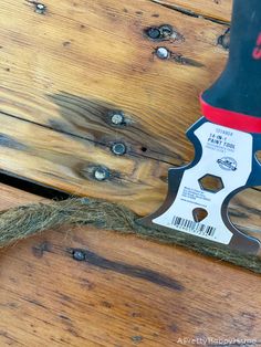 a hammer that is sitting on top of a wooden table next to some string and nails