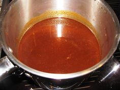 a metal bowl filled with liquid on top of a stove