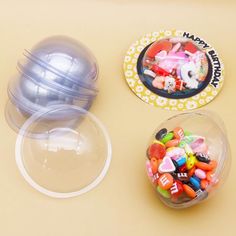 three plastic bowls with candy in them on a table