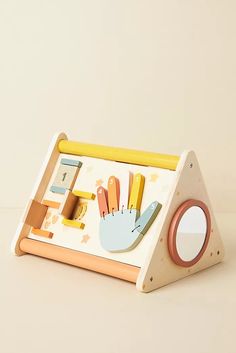 a wooden toy with scissors, pencils and other things on it's tray