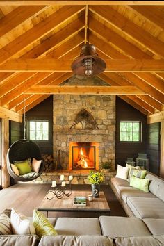 a living room filled with furniture and a fire place in the middle of an open floor plan