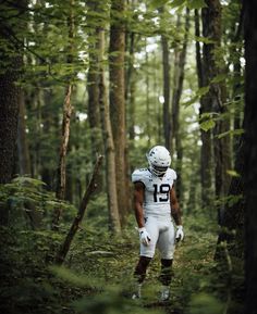 a football player is walking through the woods