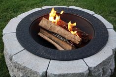 an outdoor fire pit with logs and flames