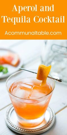 a glass filled with orange juice and garnished with an orange peel on top