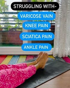 a woman laying on top of a yoga mat in front of a window