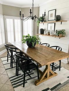 a dining room table with black chairs and a potted plant on top of it