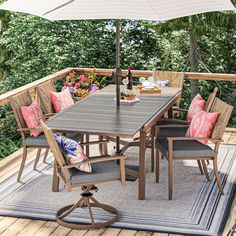 an outdoor table and chairs on a deck with an umbrella over the dining room area