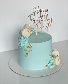 a birthday cake with blue frosting and gold decorations