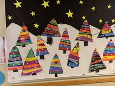 a bulletin board decorated with christmas trees and stars