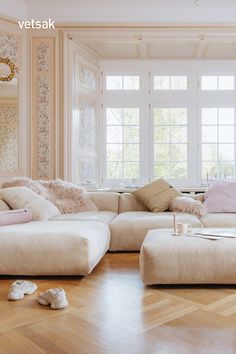 a living room filled with lots of furniture next to a large white couch and window