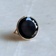 ITEM DESCRIPTION: >>The ring is made from Solid 14K Yellow Gold. >>Gemstone used is absolutely natural and ethically sourced. >>Natural Flat Cut Black Onyx in round shape and bezel setting is studded on it with utmost precision. Gem: Black Onyx Gem size & shape: 20x20 mm and Round Gem weight: 9.05 Carats Gold purity: 14K (58.33% approx.) Gold weight: 2 grams Gross weight of ring: 3.81 grams The Gold purity is guaranteed and it comes with authentic 14K gold hallmark. Since these Rings are handmad Black Sapphire Ring In 14k Gold, Black Sapphire Ring With Polished Finish For Anniversary, Formal Black Sapphire Ring In 14k Gold, Anniversary Black Sapphire Ring With Polished Finish, Formal Black Sapphire Ring With Polished Finish, Black Oval 14k Gold Rings, Black Oval Jewelry With Bezel Setting, Black Sapphire Ring In 14k Gold As Gift, Black Round Ring With Bezel Setting