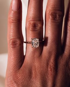 a woman's hand with a ring on it and a diamond in the middle