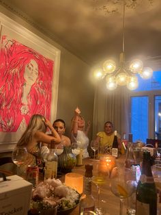 a group of people sitting around a table with wine glasses and bottles on top of it