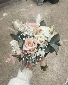 a bridal bouquet is held by someone on the street