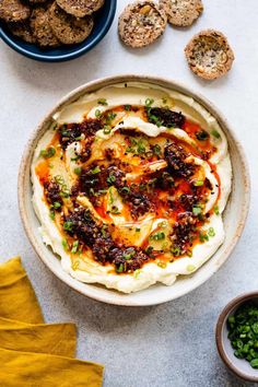 a bowl filled with food next to some crackers