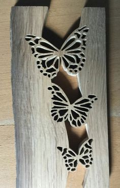 a wooden frame with two butterflies cut out of it