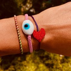 Heart Bracelet with a single red threaded heart attached to a colorful threaded bracelet. Each item is handmade and unique, may have slight variations. This item is adjustable Circumference of Bracelet: 6.25-9" Please allow 3-5 days for items to ship Handmade in Greece OIYA Adjustable Red Heart Charm Bracelet, Handmade Nylon Thread Bracelets For Friendship, Handmade Adjustable Nylon Thread Bracelets, Handmade Adjustable Nylon Thread Bracelet, Red Heart-shaped Braided Bracelets As Gift, Adjustable Red Heart Friendship Bracelets, Red Heart-shaped Braided Bracelets For Gifts, Red Heart-shaped Braided Bracelet As Gift, Handmade Adjustable Evil Eye Bracelet For Friendship