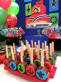 a table topped with cake pops covered in chocolate