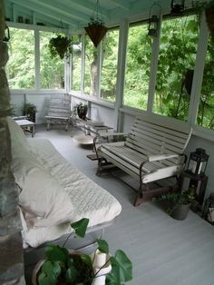 a porch with white furniture and lots of windows