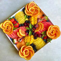 an arrangement of fruit is arranged on a square plate