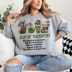 a woman sitting on a couch wearing a sweatshirt that says cup of fuckofe