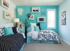 two beds in a room with blue walls and black and white bedding on them