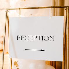 a reception sign hanging from a gold frame