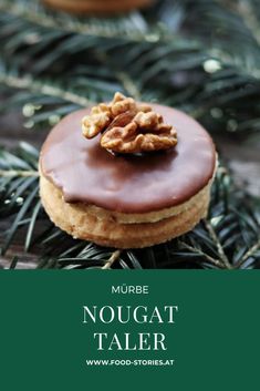 a close up of a doughnut on a pine tree with the words mure nougat taller above it