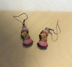 a pair of earrings with cartoon characters on them