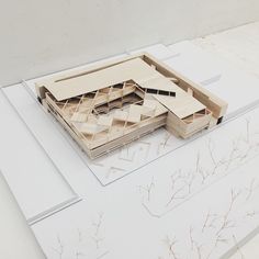 an architectural model of a building on top of a white surface