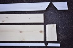 some pieces of wood sitting on top of a black table next to white trimmings