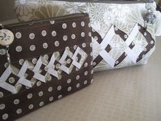 three purses with white and brown designs on them sitting on a counter next to each other