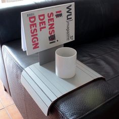 a coffee cup sitting on top of a table next to a sign that says design