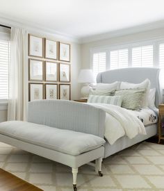 a white bed sitting next to a window in a bedroom