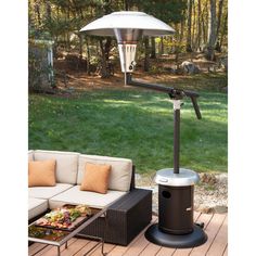 an outdoor patio heater sitting on top of a wooden deck next to a couch