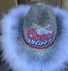 a close up of a hat with fuzzy fur around the brim and logo on it