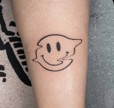 a person with a smiley face tattoo on their left arm and the outline of a cat's head