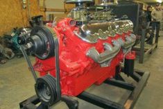 a red engine sitting on top of a metal stand