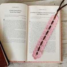 an open book with pink and brown beads on it