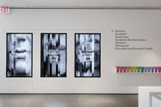 three black and white posters on the wall in an art gallery